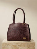 Deep burgundy hand-tooled leather handbag with shoulder strap and gold hardware, handmade in México